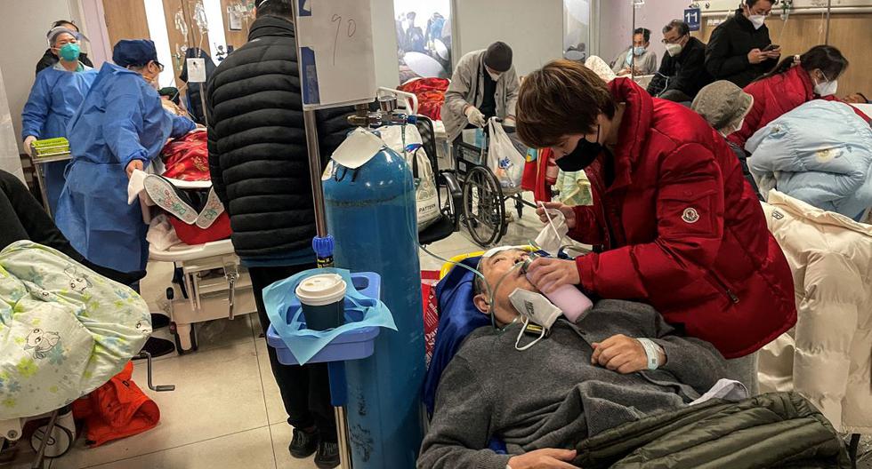 Una mujer ayuda a un paciente en el hospital de Tongren en Shanghái, China, el 3 de enero de 2023. (Héctor RETAMAL / AFP).