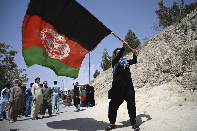 Un afgano ondea la bandera nacional mientras celebran el 102 ° Día de la Independencia de Afganistán en Kabul, el 19 de agosto de 2021. (Foto de WAKIL KOHSAR / AFP).