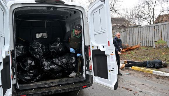 Un trabajador comunal permanece en una camioneta cargada con cadáveres de civiles asesinados en Bucha. (Sergei SUPINSKY / AFP).