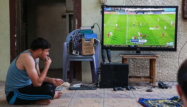 Syrian football fans watch the FIFA World Cup 2018 qualification football match between Iran and Syria on television at a house in the rebel-controlled town of Hamouria, in the eastern Ghouta region on the outskirts of the capital Damascus on September 5, 2017. / AFP / ABDULMONAM EASSA