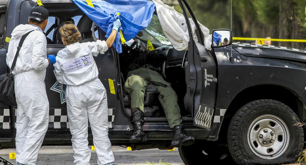 Personal forense trabaja junto a un cadáver en la escena del crimen donde fueron asesinados cuatro policías en Tonalá, Estado de Jalisco, México, el 3 de septiembre de 2018. (Ulises Ruiz / AFP).