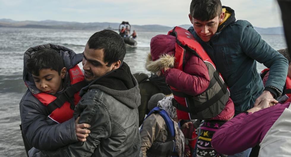 Los miembros de una ONG ayudan esta mañana a un grupo de 15 refugiados afganos a desembarcar de un bote en la isla griega de Lesbos. (AFP)
