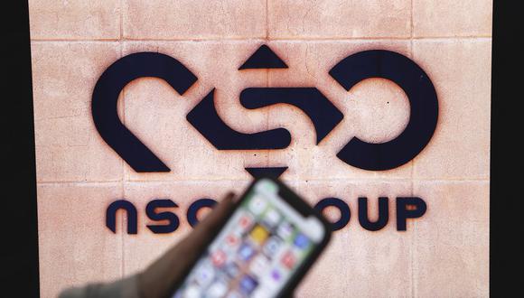 Una ilustración fotográfica muestra un teléfono móvil cerca del logotipo de la empresa NSO Group el 9 de febrero de 2022 en la ciudad israelí de Netanya. (Foto referencial de JACK GUEZ / AFP)