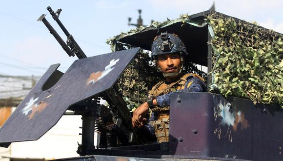 Un miembro de la policía federal de Irak se sienta dentro de un vehículo blindado en un puesto de control en una calle de Bagdad, el 29 de enero de 2021. (AHMAD AL-RUBAYE / AFP).