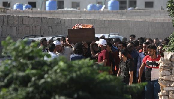 Los dolientes llevan un ataúd durante el funeral de las personas muertas por el fuego de artillería de las fuerzas del gobierno sirio, en la ciudad de Al-Bab, controlada por la oposición, en la frontera con Turquía en la provincia norteña de Alepo, el 19 de agosto de 2022.  (Foto de Bakr ALKASEM / AFP)