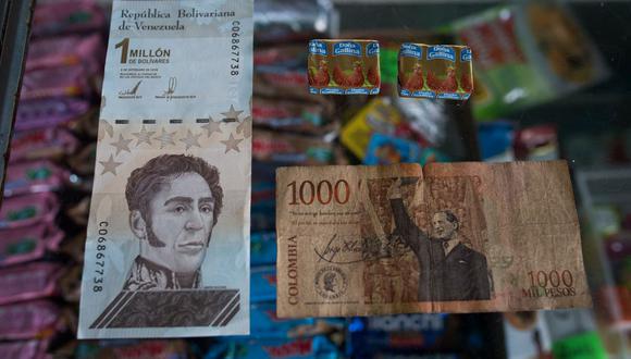 Un billete de 1 millón de bolívares venezolanos (izquierda), que equivale a 1.000 pesos colombianos (derecha), que vale para comprar dos condimentos en una tienda de abarrotes en la ciudad de Puerto Concha, estado Zulia, Venezuela. (FEDERICO PARRA / AFP).