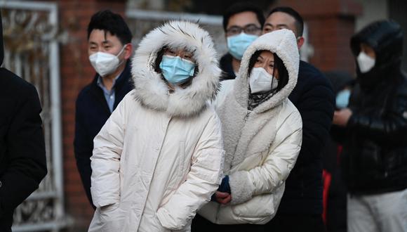 La gente espera en una larga cola para hacerse la prueba del coronavirus Covid-19 en un sitio de prueba de ácido nucleico abierto, ya que muchas estaciones de prueba están cerradas en Beijing.