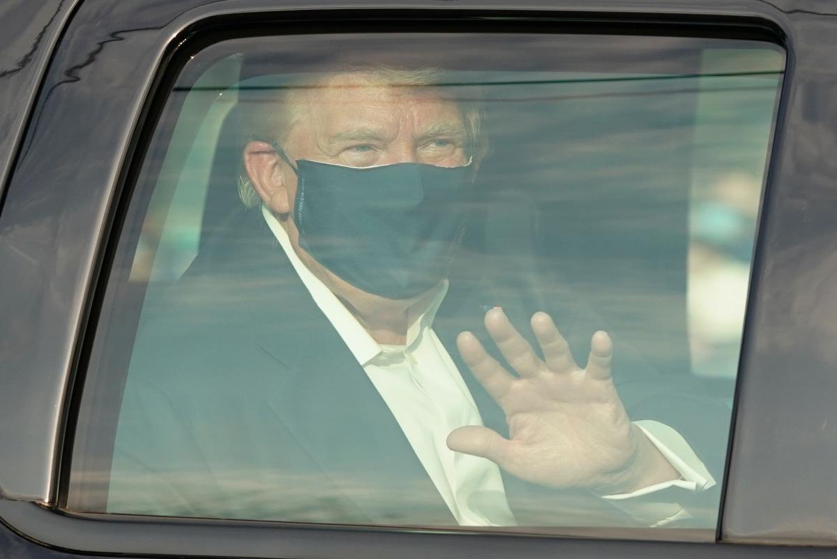 En un vehículo, el presidente de los Estados Unidos, Donald Trump, pasa junto a sus partidarios en una caravana frente al Centro Médico Walter Reed en Bethesda, Maryland. (AFP / ALEX EDELMAN).