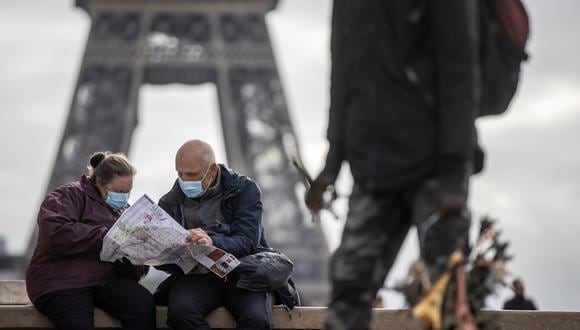 Ciudadanos con mascarilla cerca de la Torre Eiffel. (Foto: EFE)