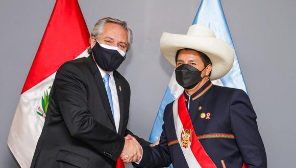 El entonces presidente del Perú, Pedro Castillo (derecha), y su homólogo de Argentina, Alberto Fernández, se dan la mano durante una reunión bilateral en Lima, el 28 de julio de 2021. (ESTEBAN COLLAZO / ARGENTINIAN PRESIDENCY / AFP).