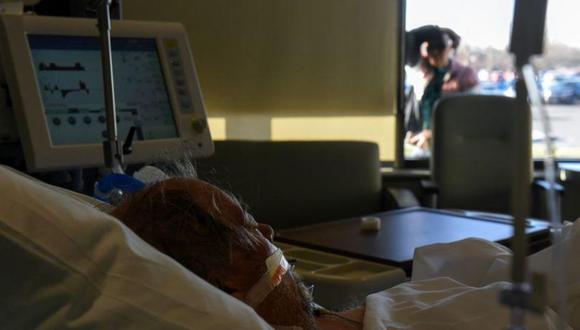 Daniel Benewiat, paciente de COVID-19, recibe tratamiento con un ventilador mientras su esposa, Tammy, lo observa desde una ventana en un hospital de la ciudad de Hutchinson, en Kansas. (Foto: Reuters)