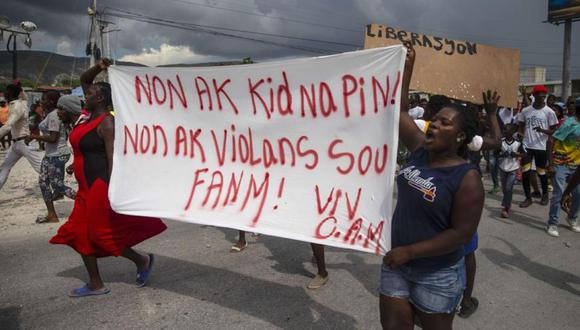Gente protesta con una pancarta que dice en creole "No a los secuestros, no a la violencia contra las mujeres. Viva Christian Aid Ministries". Reclama la libertad de misioneros secuestrados en Titanyen, al norte de Puerto Principe, Haití. (Foto: AP /Joseph Odelyn).