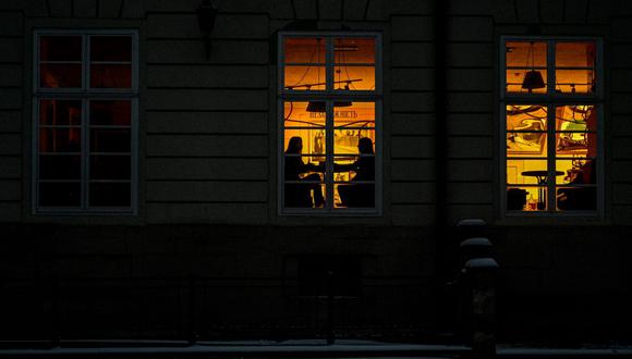 La gente se sienta en un restaurante alumbrado por un generador de energía durante un apagón en la ciudad de Lviv, en el oeste de Ucrania.