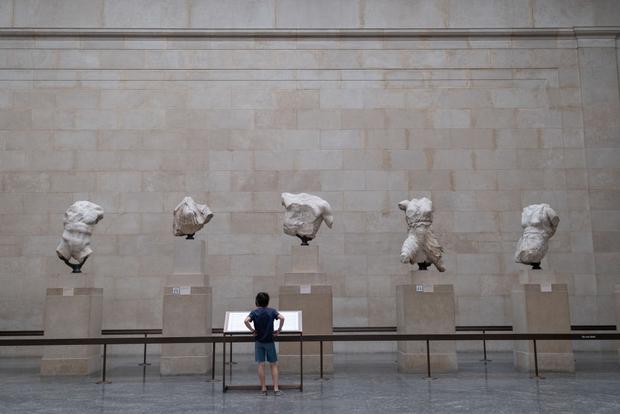 Now reopened after months of closure during the coronavirus pandemic, one of the first young visitors to have booked free tickets in advance is once again enjoying the Elgin Marbles and other historical artifacts at the British Museum in London.  (Photo: Richard Baker / Getty Images).