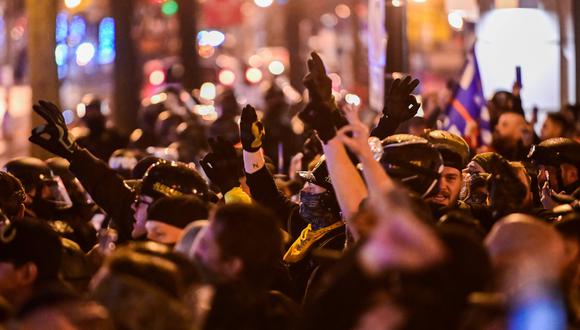 Miembros del grupo de extrema derecha Proud Boys utilizan sus manos para hacer el gesto de poder blanco, mientras se reúnen cerca de un grupo de Black Lives Matter, en Washington. (REUTERS/Erin Scott)