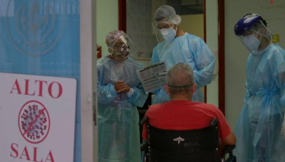 Los paramédicos Juan Carlos Mojica y Yushara Hernández llegan al hospital con un hombre de 52 años con problemas respiratorios, en la vereda Cerro Viento en Ciudad de Panamá. (Foto: AFP).