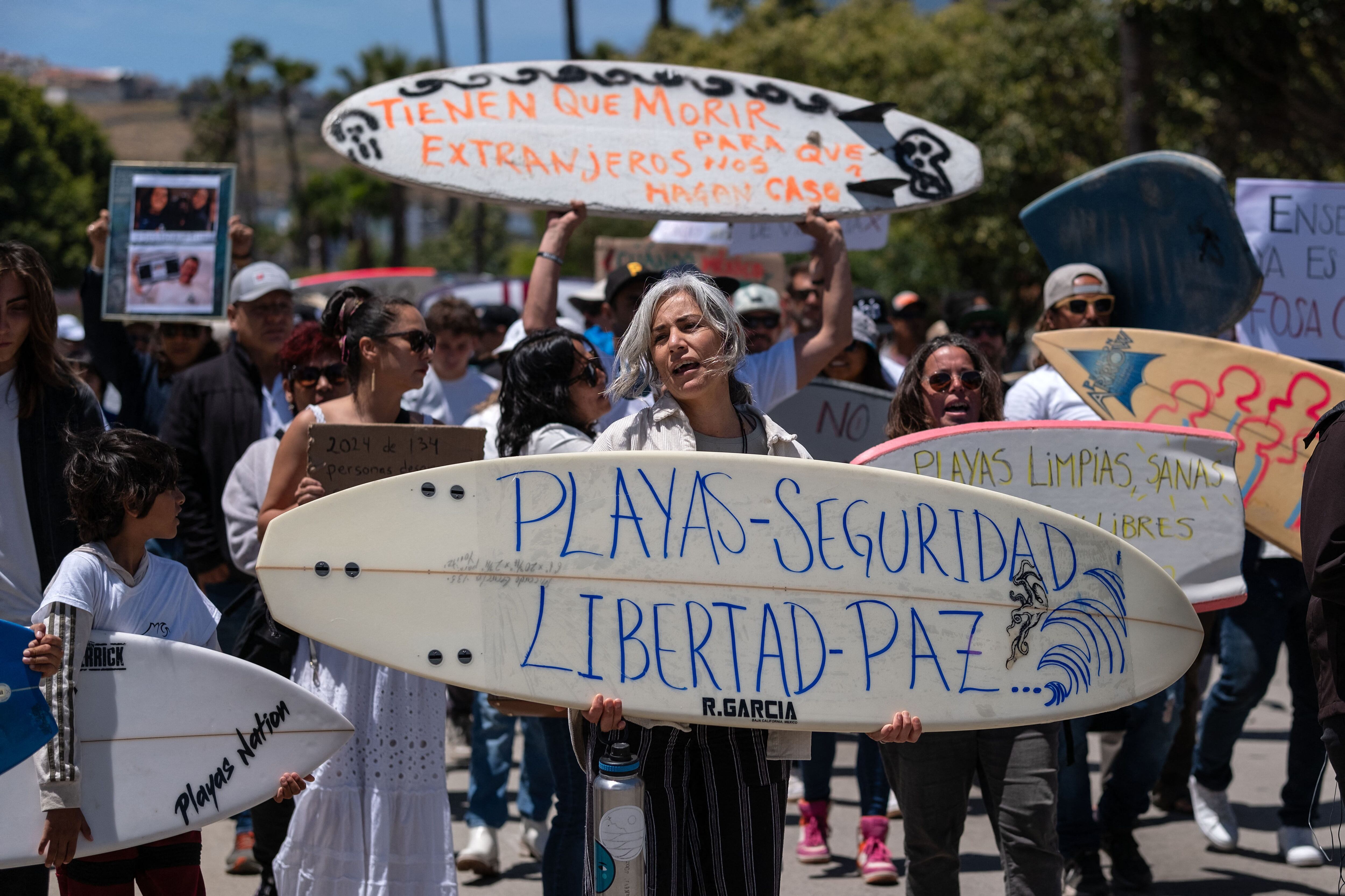 A woman holds a surfboard that says 