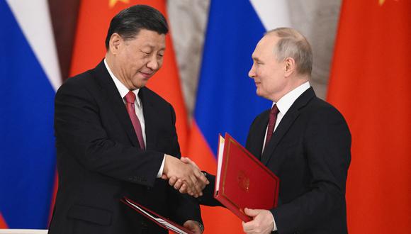 El presidente ruso Vladimir Putin y el presidente chino Xi Jinping se dan la mano durante una ceremonia de firma luego de sus conversaciones en el Kremlin en Moscú el 21 de marzo de 2023. (Foto de Vladimir ASTAPKOVICH / SPUTNIK / AFP)