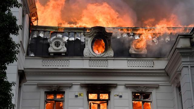 Las llamas envuelven la Universidad Pedro de Valdivia luego de una protesta contra el gobierno del presidente chileno Sebastián Piñera en Santiago. (Foto: AFP).