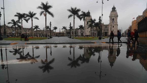 Desde la noche del sábado una intensa llovizna cae sobre Lima. Pese a ello, algunas personas se acercaron a la Plaza de Armas en donde se transmite la final de Rusia 2018. (Foto: Lino Chipana / El Comercio)