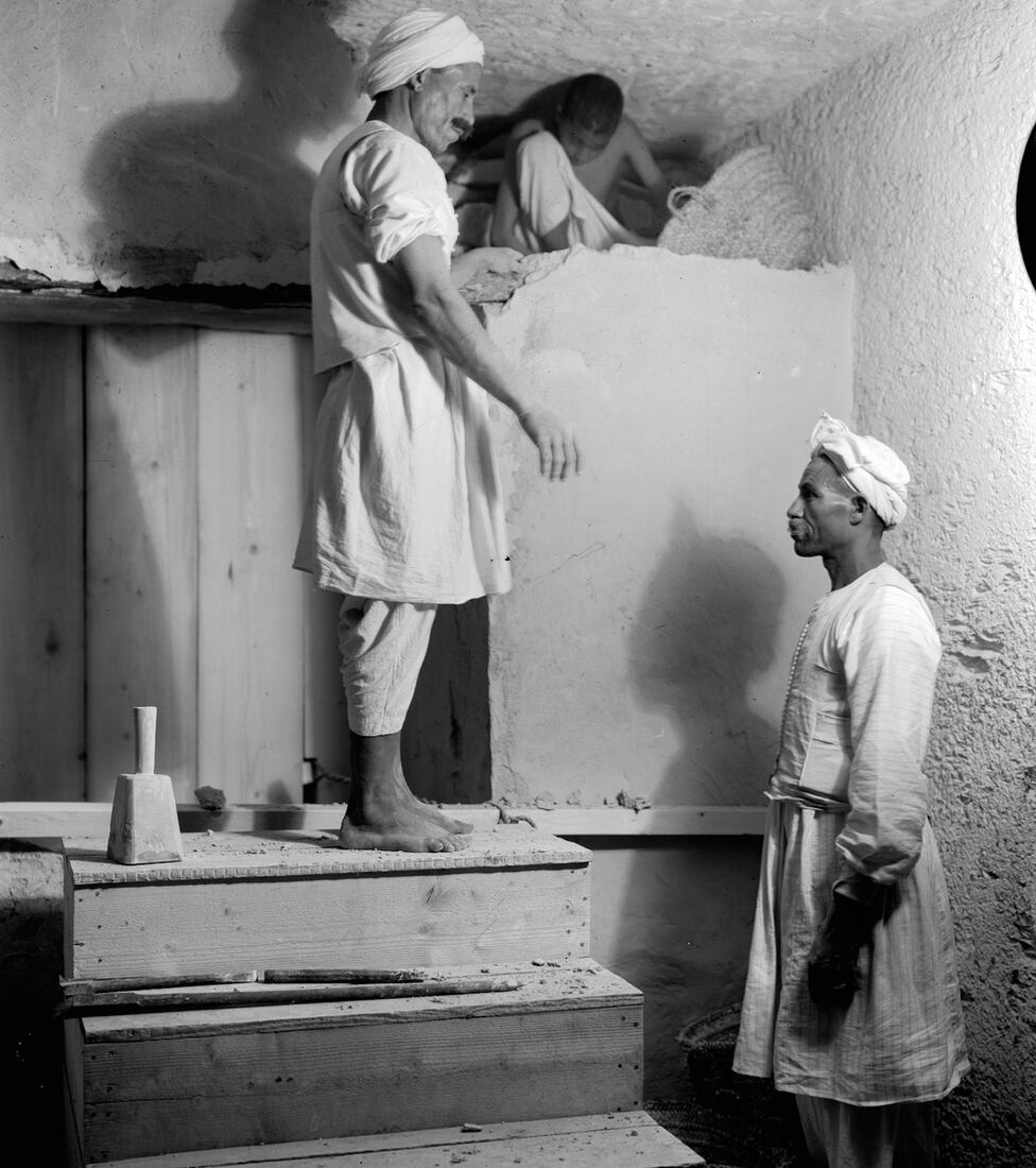 Egyptian foremen and a child dismantle a partition to open Tutankhamun's burial chamber.  (HARRY BURTON/GRIFFITH INSTITUTE, UNIV. OF OXFORD).