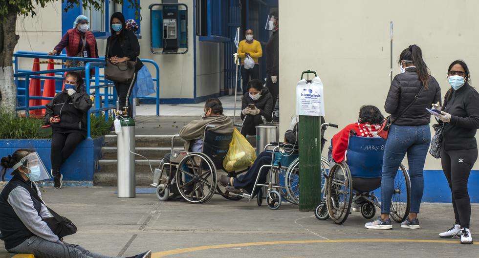 Las personas esperan recibir atención médica fuera del área de emergencia en el Hospital Alberto Sabogal en Lima, el 27 de mayo de 2020. (Foto por ERNESTO BENAVIDES / AFP).