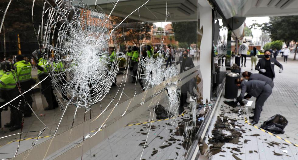 Trabajadores limpian los vidrios rotos que dejaron las manifestaciones como protesta contra la realización del I Encuentro Regional de Foro Madrid organizado por Vox en Bogotá, Colombia. (EFE/Carlos Ortega).