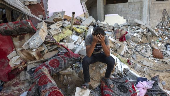 Un joven palestino reacciona sentado sobre los escombros de una casa destruida tras un ataque militar israelí contra el campo de refugiados de Rafah, en el sur de la Franja de Gaza, el 15 de octubre de 2023, en medio de las batallas en curso entre Israel y el grupo islamista palestino Hamás. (Foto de MOHAMMED ABED/AFP)