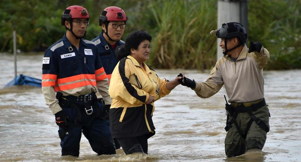 Mujer es evacuada por rescatistas de la zona inundada. (Foto: EFE)