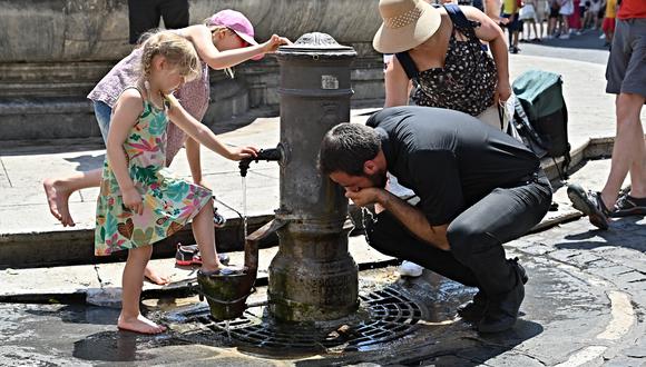Los turistas se refrescan y beben en una fuente en Roma, en medio de una feroz ola de calor que arrasa Europa, el 19 de julio de 2022.  Foto: Andreas SOLARO / AFP