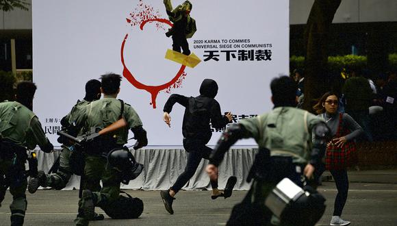 La policía antidisturbios persigue a un hombre enmascarado durante una manifestación que exige la democracia electoral y llama al boicot al Partido Comunista Chino y a todas las empresas que lo respaldan en Hong Kong. (Foto: AP)