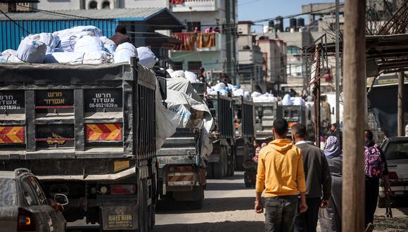 Camiones que transportan ayuda humanitaria avanzan por una calle de Rafah, en el sur de la Franja de Gaza, el 10 de marzo de 2024. (Foto de MOHAMMED ABED / AFP)