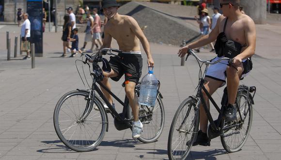 Unos turistas pasean con una botella con agua por el centro de Barcelona en plena ola de calor. Foto: EFE/Marta Pérez