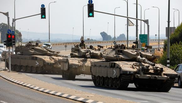 Tanques israelíes Merkava ruedan por una carretera en las afueras de la ciudad norteña de Kiryat Shmona, cerca de la frontera con el Líbano, el 8 de octubre de 2023. (Foto de JALAA MAREY / AFP)