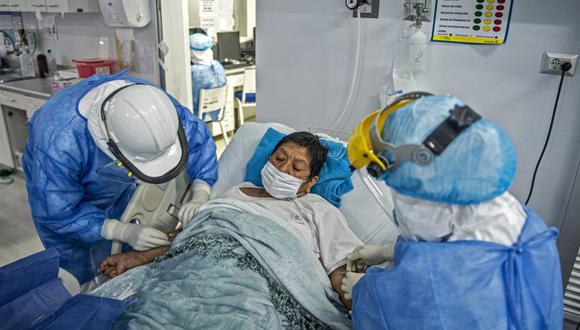 Los profesionales de la salud ayudan a un paciente con COVID-19 en la Unidad de Cuidados Intensivos del Hospital Alberto Sabogal Sologuren, en Lima, en medio de la nueva pandemia de coronavirus. (Foto: Ernesto BENAVIDES / AFP)