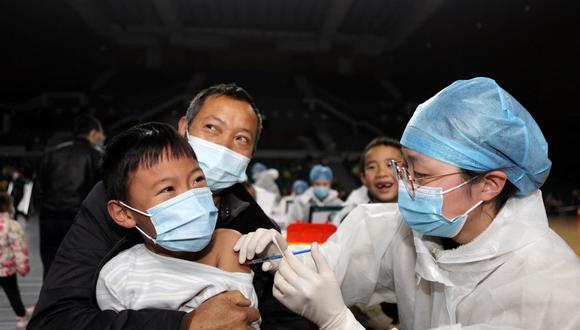 Esta foto tomada el 9 de noviembre de 2021 muestra a niños siendo vacunados contra el coronavirus covid-19 en un gimnasio en Yongchuan, Chongqing, en el suroeste de China. (AFP).