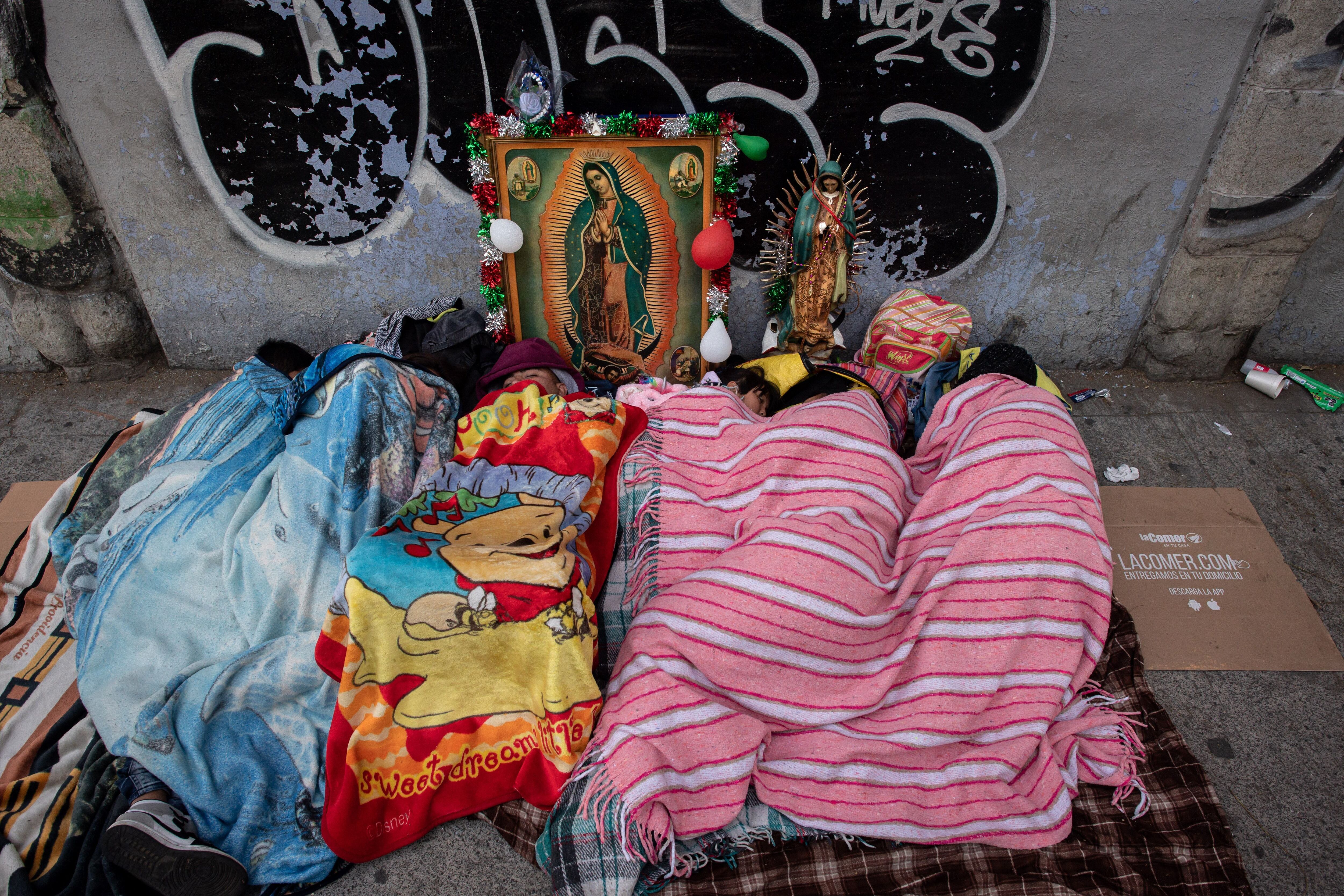 Pilgrims sleep in the street next to an image of the Virgin of Guadalupe outside the Basilica of Guadalupe in Mexico City.