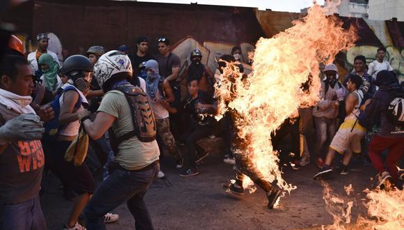 Un hombre corre envuelto en llamas luego de ser golpeado por manifestantes de la oposición de Venezuela en Caracas. (AFP).