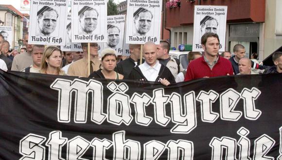 Activistas de extrema derecha se reúnen en las calles y sujetan una pancarta en la que se lee "¡Los mártires nunca mueren!", durante una manifestación en el 2004 para conmemorar el 17 aniversario de la muerte de Rudolf Hess, en Wunsiedel (Alemania). (Foto: EFE)
