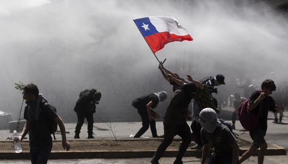 La policía reprime una manifestación en Santiago. (Photo by CLAUDIO REYES / AFP).