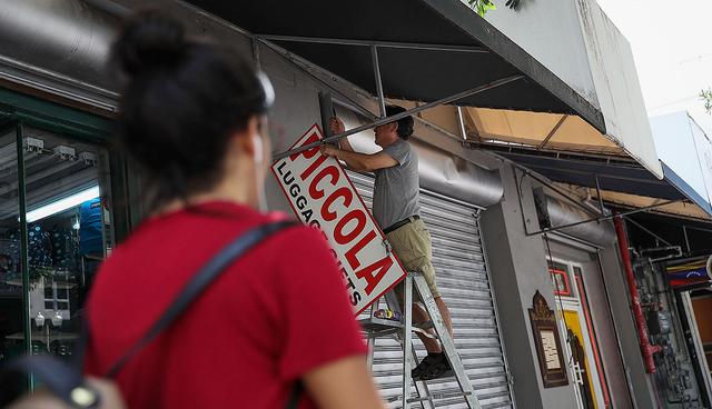 MIAMI, FL - SEPTEMBER 07: 07: A business owner takes down a sign as he prepares for Hurricane Irma on September 7, 2017 in Miami, Florida. The state of Florida is in the track of where the hurricane may make landfall.   Joe Raedle/Getty Images/AFP
== FOR NEWSPAPERS, INTERNET, TELCOS & TELEVISION USE ONLY ==
