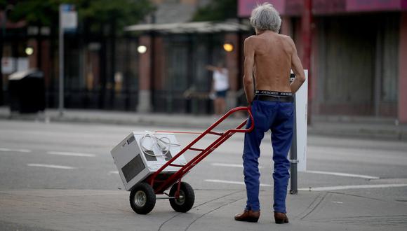 Un hombre sin polo transporta una ventilador para soportar las altas temperaturas que se registran en Vancouver, Canadá. Bloomberg