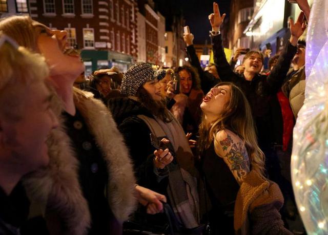 La gente festeja en una calle mientras los pubs cierran por la noche debido a las restricciones de nivel 3 en Soho, Londres. (Foto: REUTERS/Henry Nicholls)