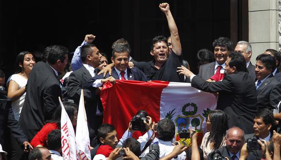 Un partidario abraza a  Ollanta Humala (centro) mientras sostiene una bandera peruana después de conocer la decisión final del tribunal de una disputa marítima de décadas entre Perú y Chile, en el Palacio de Gobierno en Lima el 27 de enero de 2014.