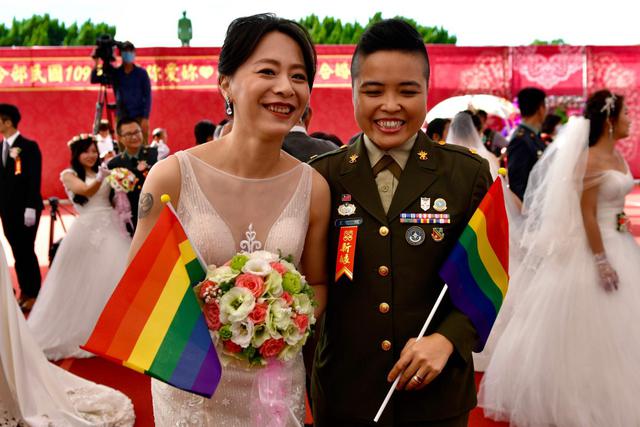 La pareja del mismo sexo recién casada Wang Yi (derecha) y Meng Yumi posan para una fotografía durante una boda masiva en el Cuartel General del Comando del Ejército de Taiwán en Taoyuan, el 30 de octubre de 2020. (AFP / Sam Yeh).