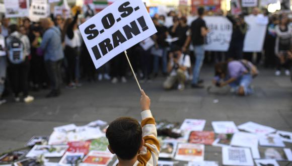Un niño sostiene un cartel durante una manifestación en apoyo de la mujer kurda Mahsa Amini el 1 de octubre de 2022 en Madrid, luego de su muerte en Irán.  (Foto por ÓSCAR DEL POZO / AFP)