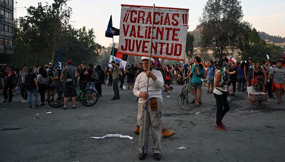 Un anciano sostiene un cartel que dice "Gracias, valiente joventud" durante una protesta contra el gobierno en Santiago de Chile. (Foto: AFP)