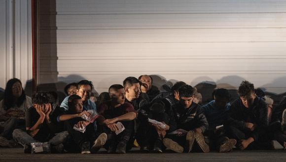 Los migrantes esperan un autobús que los lleve a un centro de procesamiento después de que se entregaron a los agentes de la Patrulla Fronteriza de los EE. UU. después de cruzar desde México en Frontón, Texas, el 12 de mayo de 2023. (Foto de ANDREW CABALLERO-REYNOLDS / AFP)