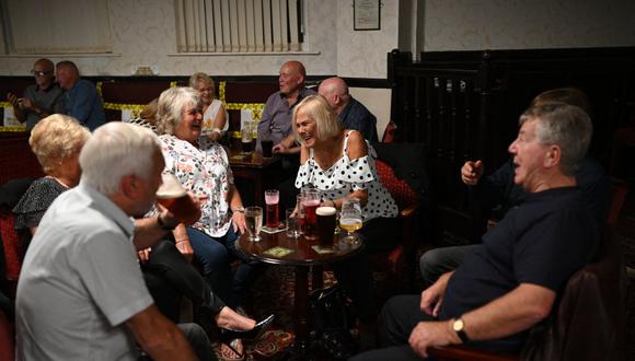 En esta foto de archivo tomada el 4 de julio de 2020, la gente disfruta de una bebida dentro del Burnley Miners Working Men's Social Club en Burnley, noroeste de Inglaterra, en plena pandemia de coronavirus. (Foto de Oli SCARFF / AFP).