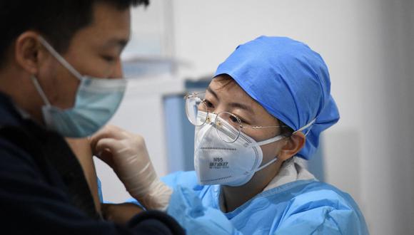 Un trabajador médico inocula a un hombre con una dosis contra el coronavirus en el Museo de Planificación Urbana de Chaoyang, en Beijing (China), el 15 de enero de 2021. (Noel Celis / AFP).